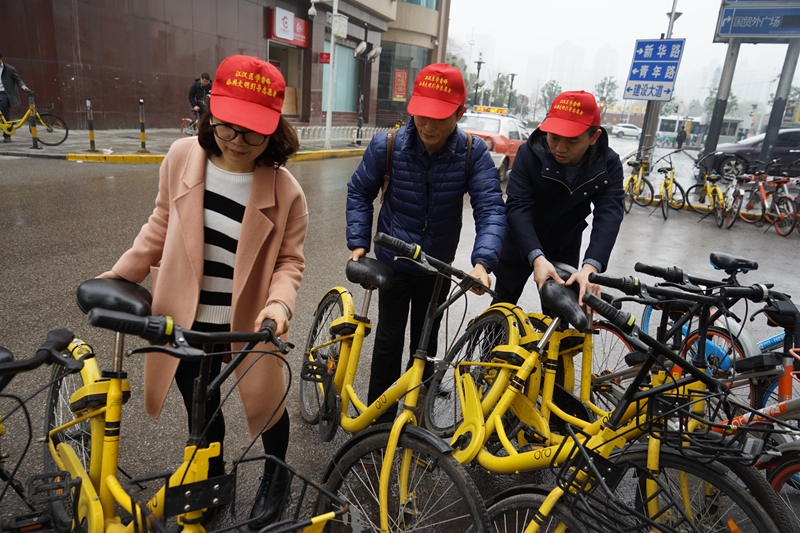 3月5日学雷锋纪念日，民革武汉市委会开展志愿服务活动，在街头整理随意停放的共享单车。